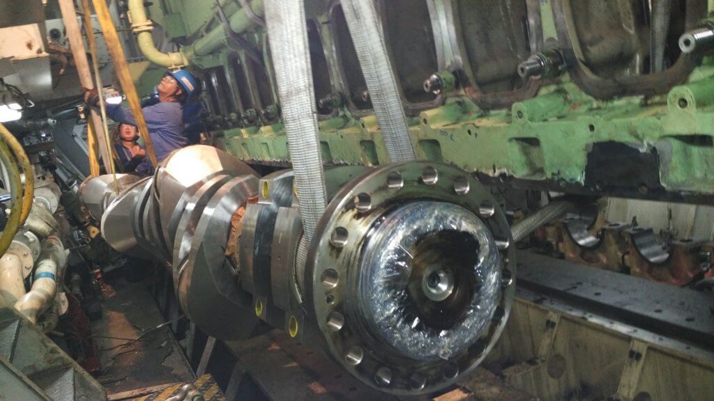 Close-up of crankshaft and camshaft components during replacement