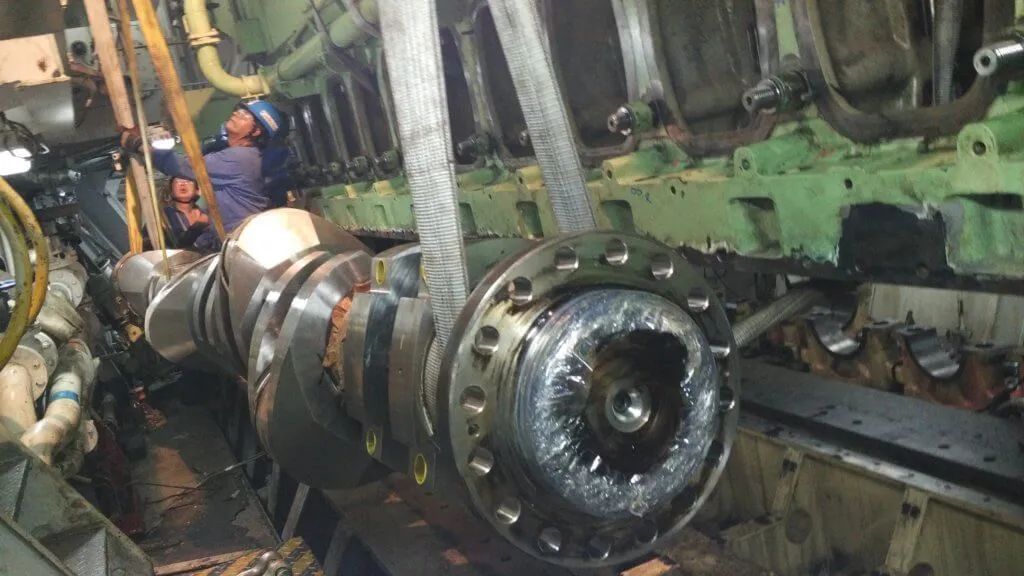 Close-up of crankshaft and camshaft components during replacement